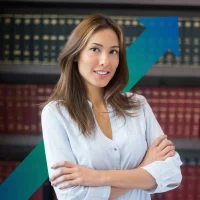 A woman in a blouse stood in front of law books, smiling, chartered corporate commercial surveyor, business rates assessment